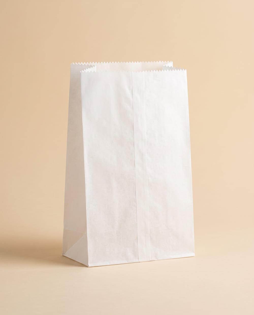 White greaseproof paper bakery counter bag with a serrated top edge, no handles