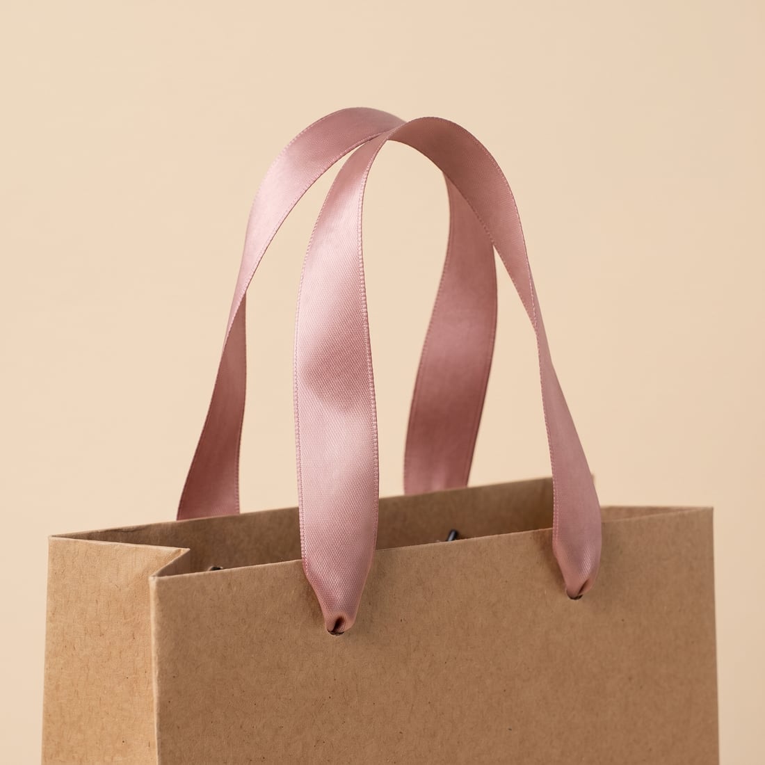 Satin ribbon on a kraft paper bag, close up